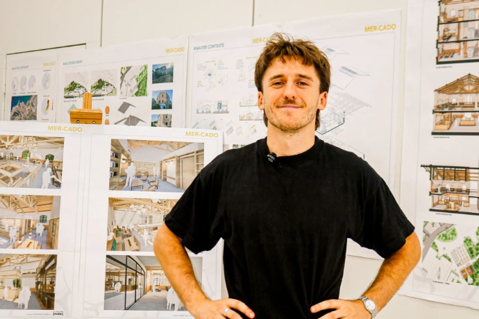 Portrait d'un alumni ESDAC devant ses planches de projet en architecture d'intérieur